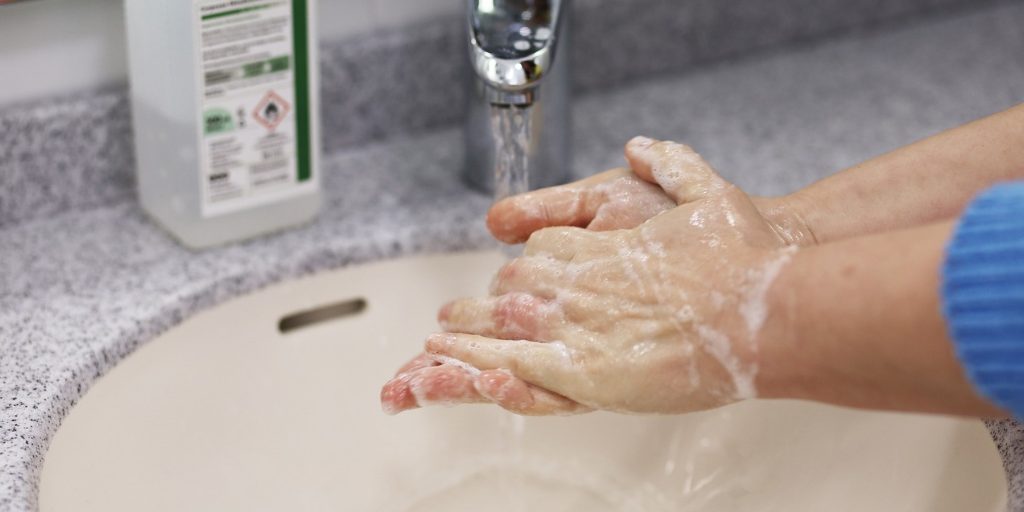 Hände werden im Waschbecken mit Seife gewaschen